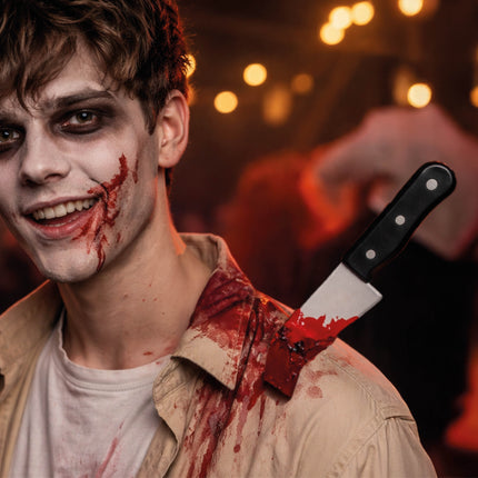Halloween-låtsaskniv i axeln