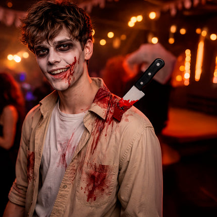 Halloween-låtsaskniv i axeln